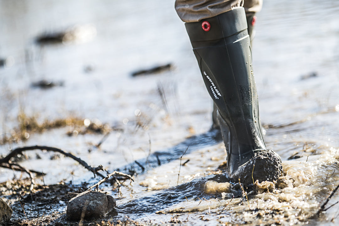 Trabajador pisando barro con la bota Dunlop Purofort+ Full Safety (Verde Oscuro / Negro)