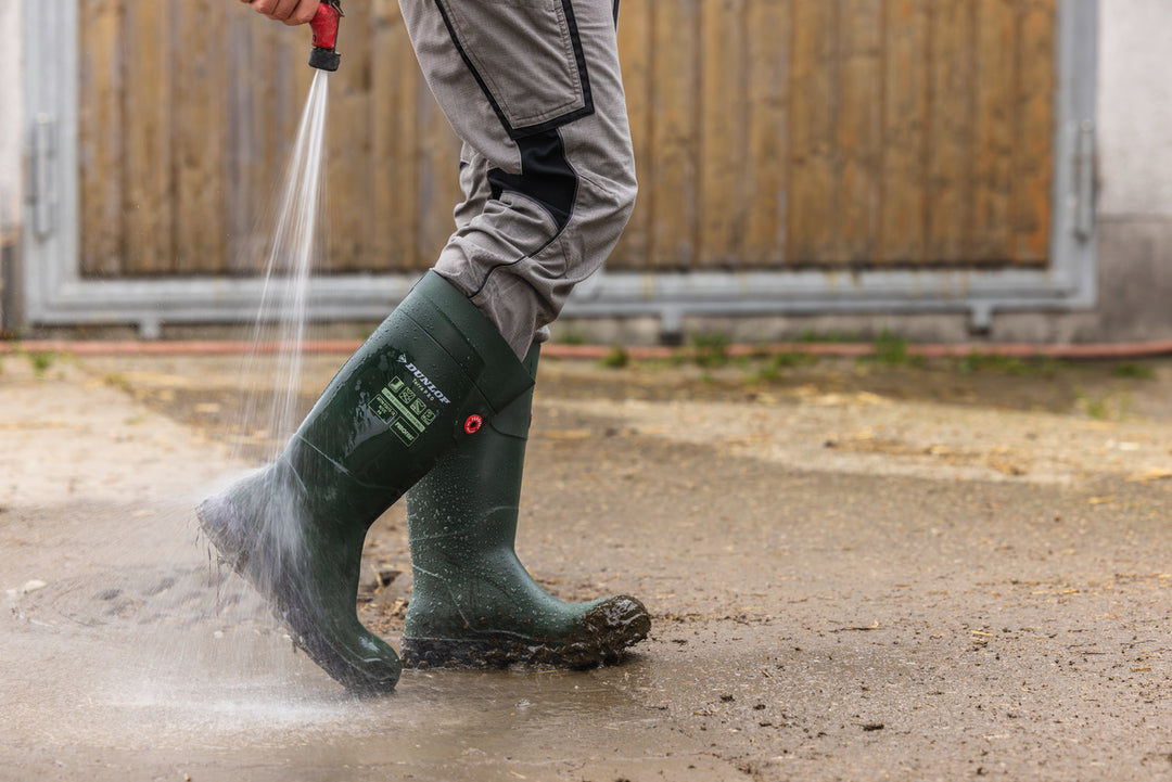 Ganaderos lavándose las botas Dunlop Purofort TerraPRO Full Safety (Verde/Negro) con manguera