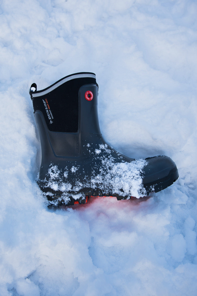 Bota Dunlop Snugboot Heavy Duty Calf Full Safety Media Caña para Trabajos Pesados tirada en la nieve y cubierta