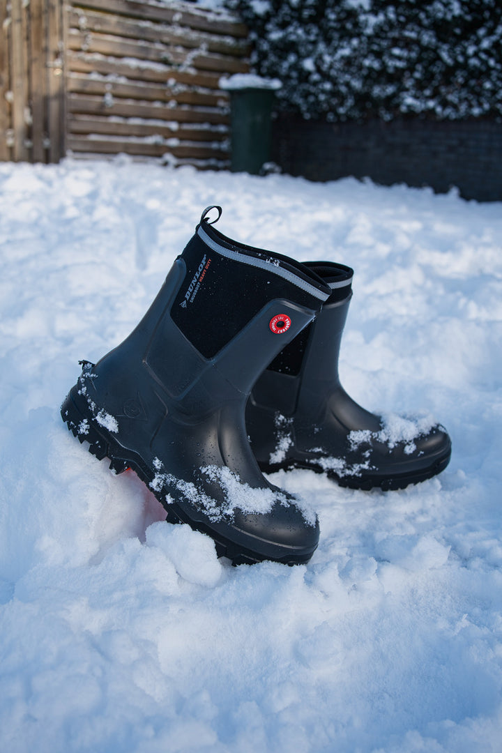 Botas Dunlop Snugboot Heavy Duty Calf Full Safety Media Caña para Trabajos Pesados pisando la nieve