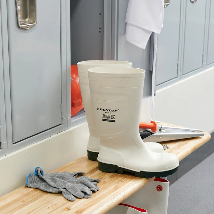 Botas Dunlop Work-It S4 (Blanco) sobre un banco con herramientas