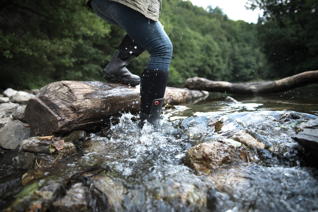 Hombre cruzando el río con las botas Dunlop Snugboot Pioneer